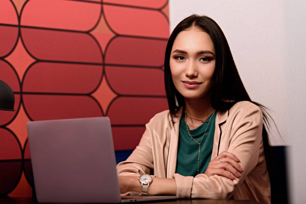 Young Asian Businesswoman Sitting At Table With La B5dvgvb Scaled