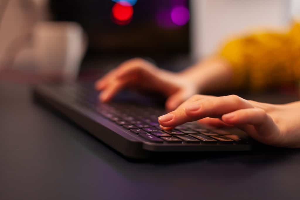 Close-up on hands of person using keyboard